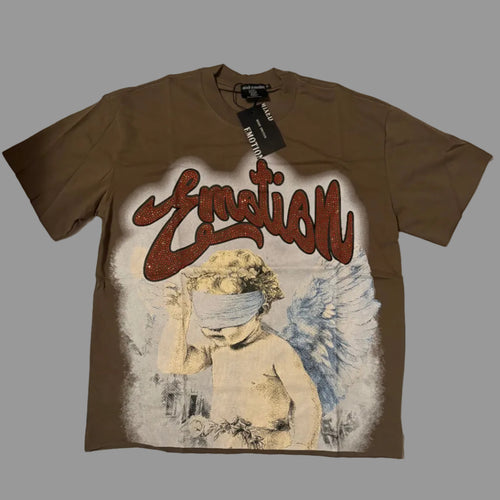 A brown short-sleeve graphic t-shirt laid flat on a white fabric background. The shirt features a large front print with the word 'Emotion' in red graffiti-style lettering above an illustration of a blindfolded cherub with blue wings.
